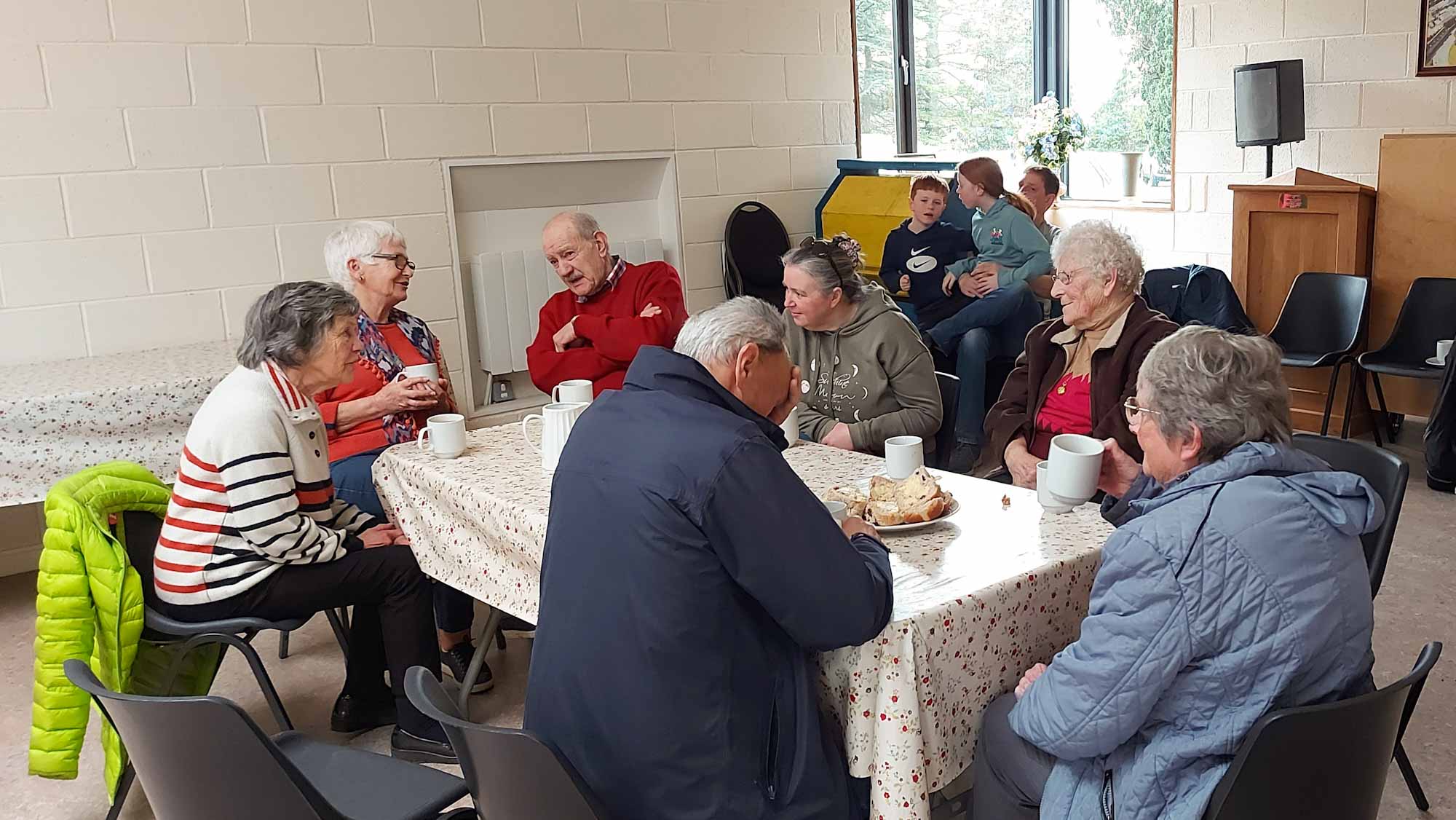 Group of people sat round chatting with a cup of tea