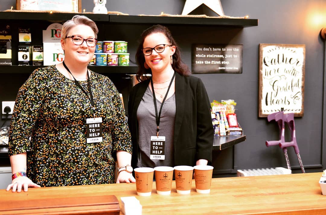 Two women serving coffee in a cafe